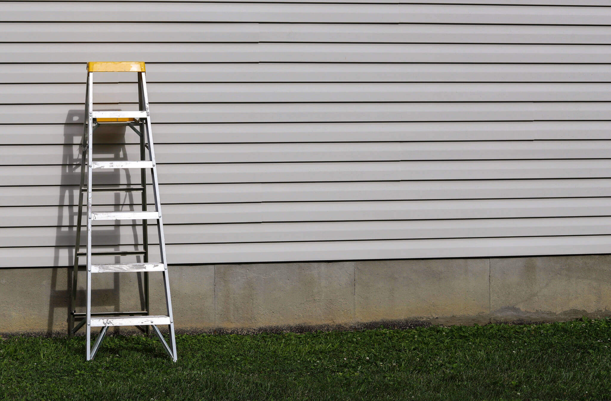 A Step Ladder Against A Side Of A Residential Home