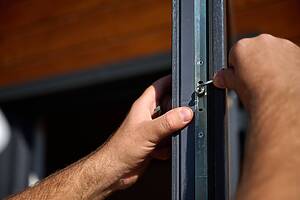 Close,up,view,of,worker,installing,door,and,window,in